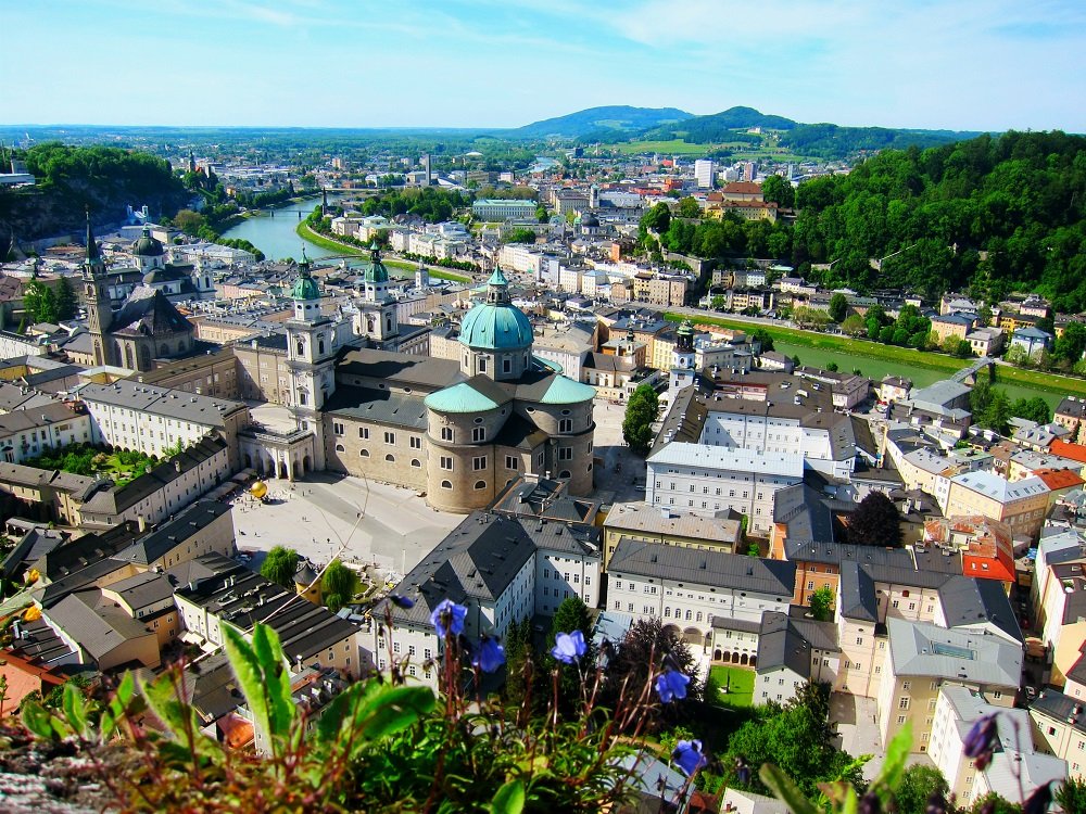 Vista panorámica de Salzburgo, Austria, mostrando el casco antiguo con su arquitectura barroca, el río Salzach y las colinas circundantes.